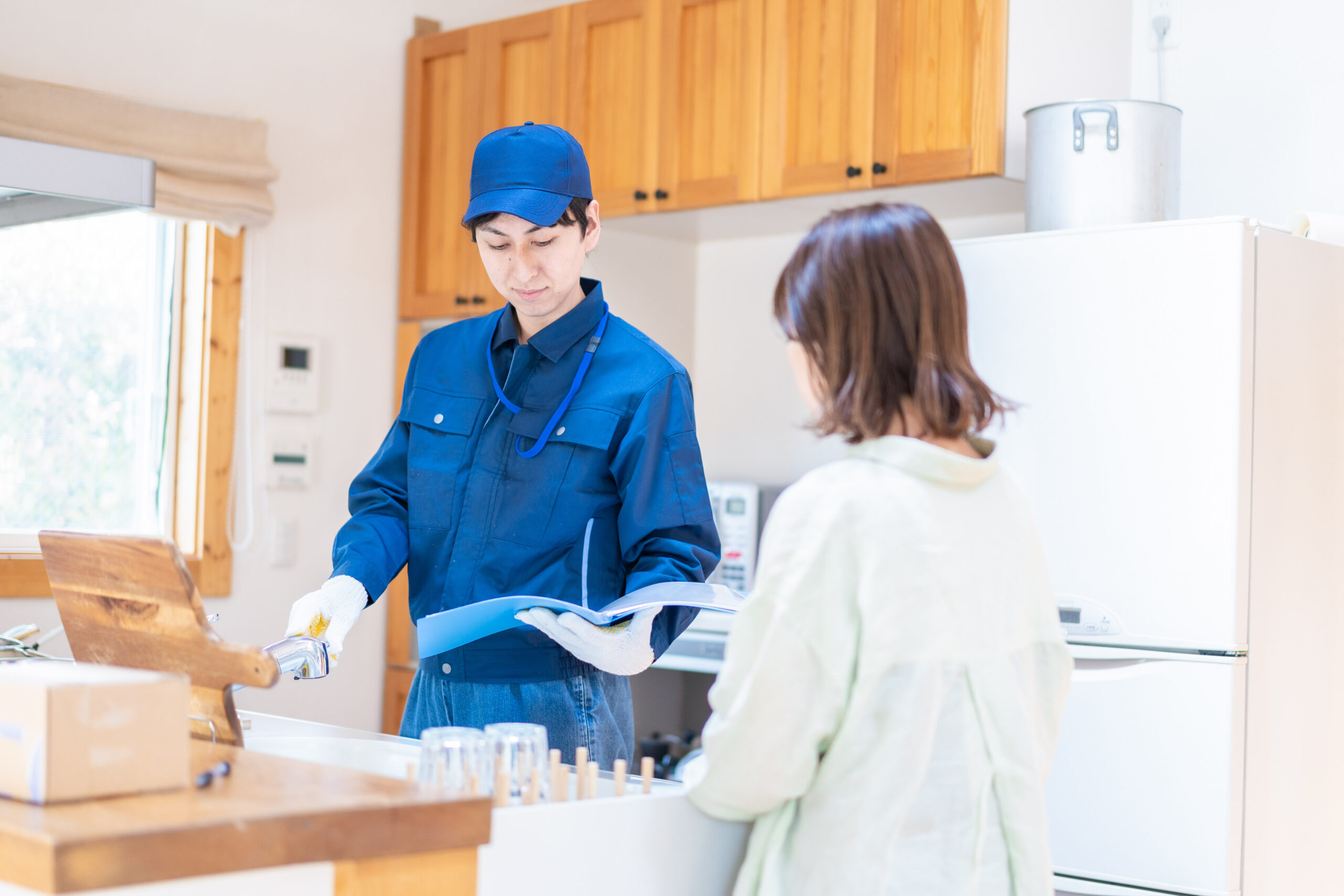 業者に家のメンテナンスをしてもらう女性